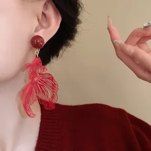 Detail showing elegant red goldfish hollow clip-on earrings in New Chinese style design