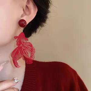 Detailed macro view of red hollow goldfish clip-on earrings in elegant New Chinese style