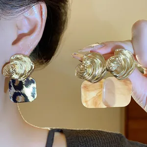 Detailansicht von Vintage-Ohrringen mit goldenen Streifen und Leopardenmuster-Anhängern.