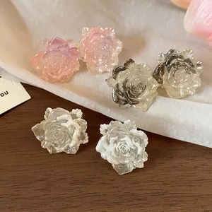 Detailed macro view of delicate resin rose stud earrings showing intricate petal textures