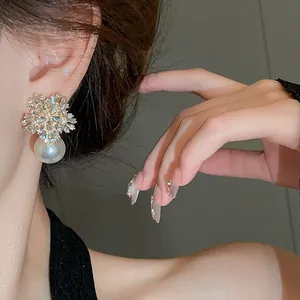 Elegant flower-shaped silver needle earrings with rhinestones and a dangling pearl