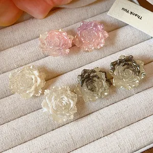 Macro view of resin rose earrings with elegant flower petal details on display tray