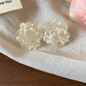 Close-up of elegant resin rose flower stud earrings with shimmering texture detail