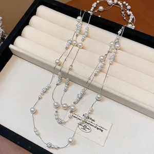 Vista dettagliata di una elegante collana di perle a più strati in un portagioie color beige