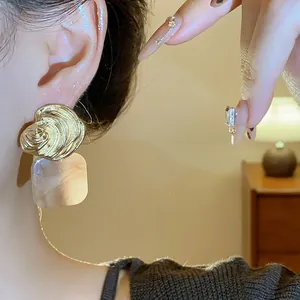 Nahaufnahme eines Vintage-Ohrrings mit goldenem Streifen und Marmor-Anhänger