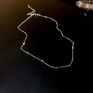 Vue détaillée d'un collier en chaîne argentée avec des perles colorées