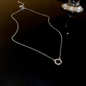 Détail d'un collier en argent doté d'un pendentif en forme de double cercle pavé de zircons