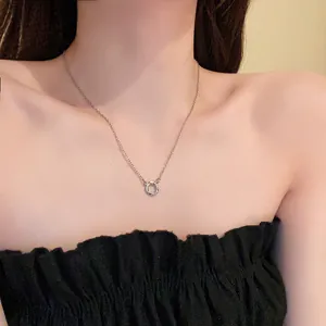 Gros plan d'un délicat collier avec pendentif cercle en zircon argenté sur un mannequin.