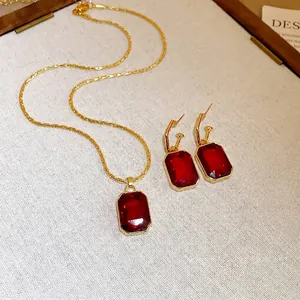 Elegant vintage gold-toned necklace and earring set with rectangular emerald-cut red gemstones