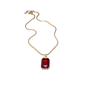 Elegant vintage gold chain necklace featuring a large rectangular faceted red gemstone pendant.