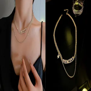 Detailed view of layered gold-tone necklace with rhinestone PRINCESS pendant and star charm