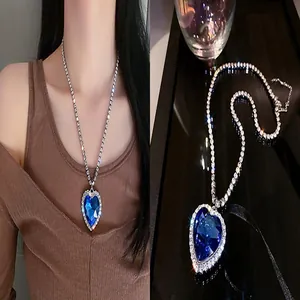 Close-up of blue heart-shaped crystal necklace with sparkling rhinestone chain detail