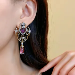 Close-up of elegant vintage style heart and teardrop earrings with rhinestones on ear