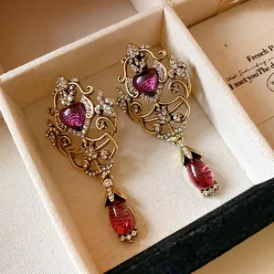 Close-up of vintage gold hollow earrings with heart and teardrop gems