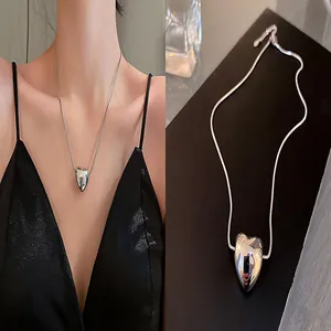 Detailed view and model wearing a shiny silver heart pendant snake chain necklace.