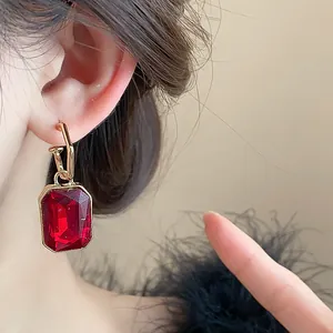 Close-up of vintage red square gemstone earring with elegant gold drop pendant design