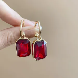 Close-up of vintage style jewelry featuring large rectangular red faceted gemstones