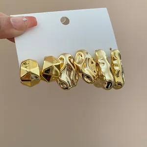 Elegante set van drie paar onregelmatige gouden geometrische oorbellen op displaykaart