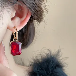 Elegant close-up shot of a vintage rectangular red crystal earring on a model's ear
