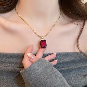 Close-up of vintage red rectangular gemstone pendant on gold-tone necklace chain
