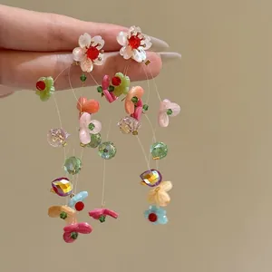Detailed macro shot of colorful dopamine floral tassel earrings featuring crystal beads.