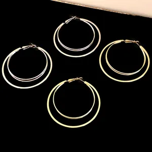 Detailed view of two pairs each of gold and silver double-layered hoop earrings.