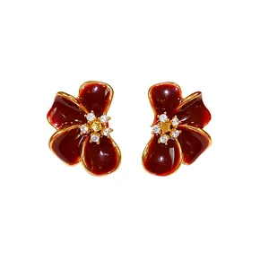 Elegant dark red enamel flower stud earrings with gold plating and sparkling zircons