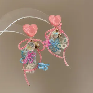 Detailed view of colorful beaded heart tassel earrings in vibrant dopamine style.