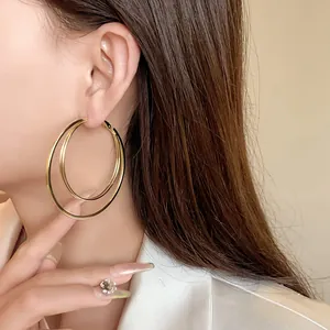 Close-up shot of elegant multi-layered gold hoop earrings worn on a female model's ear