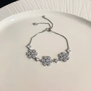 Detailed macro view of the shimmering zircon snowflake charms on the silver bracelet