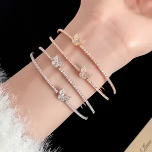 Quattro eleganti bracciali a farfalla con zirconi luccicanti al polso di una modella