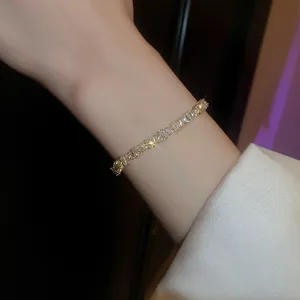 Detailed view of a minimalist gold bracelet with sparkling baguette-cut zircons