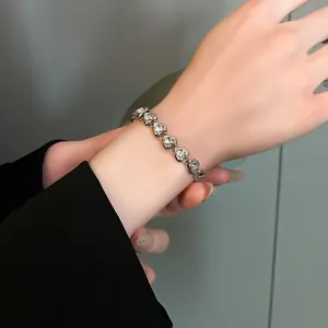Close-up of elegant silver-colored bracelet with heart-shaped zircon charms on a wrist