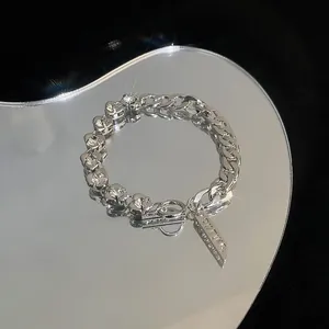 Detailed view of silver zircon flower bracelet with Cuban links and heart-shaped accents.