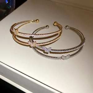 Dettaglio macro del bracciale a farfalla in zircone a doppio strato in oro e argento