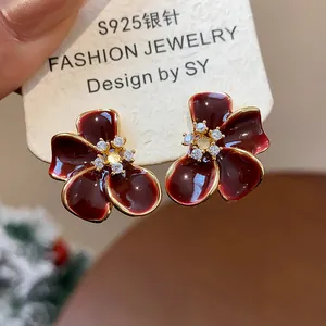 Close-up of elegant burgundy flower earrings with zircon centers on a S925 silver needle card