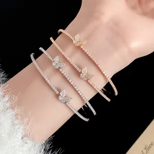 Primo piano di quattro eleganti bracciali a polsino a farfalla con zirconi vari colori