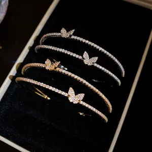 Macro dettagliata di bracciali a forma di farfalla in zircone scintillante, oro e argento.