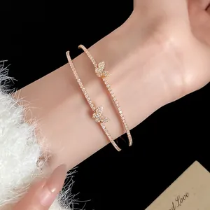 Dettaglio macro di un elegante bracciale aperto a doppio strato con farfalla e zirconi