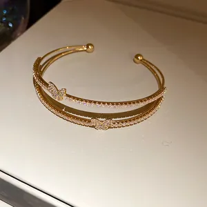 Elegante bracciale rigido a doppio strato con farfalle dorate e zirconi brillanti