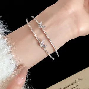 Dettaglio ravvicinato di un bracciale rigido a doppio strato con farfalla in zircone al polso.