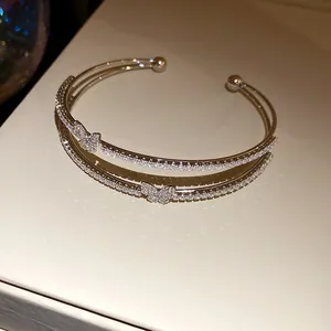Primo piano elegante di un bracciale rigido a doppio strato con farfalla e zirconi