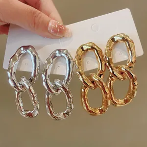 Detail of irregular oval chain link earrings in gold and silver finishes on display card.