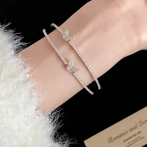 Dettaglio del bracciale aperto a doppio strato con farfalla in zircone al polso