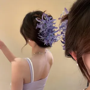 Vue détaillée d'une élégante pince à cheveux en tissu violet lys araignée sur modèle