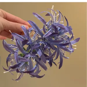 Détail d'une pince à cheveux fleur de lys araignée en tissu violet élégante pour femmes