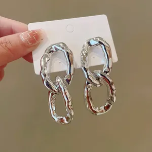 Detailed close-up of irregular textured silver interlocking oval link drop earrings set