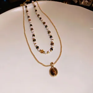 Collana a strati vintage placcata in oro con perline occhio di tigre e ciondolo ovale.