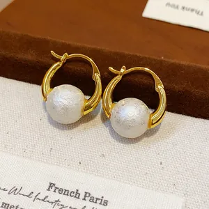 Detailed view of 18k gold plated hoop earrings featuring elegant white pearls