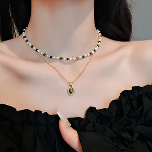 Dettaglio collana a strati vintage con perline occhio di tigre e ciondolo placcato oro